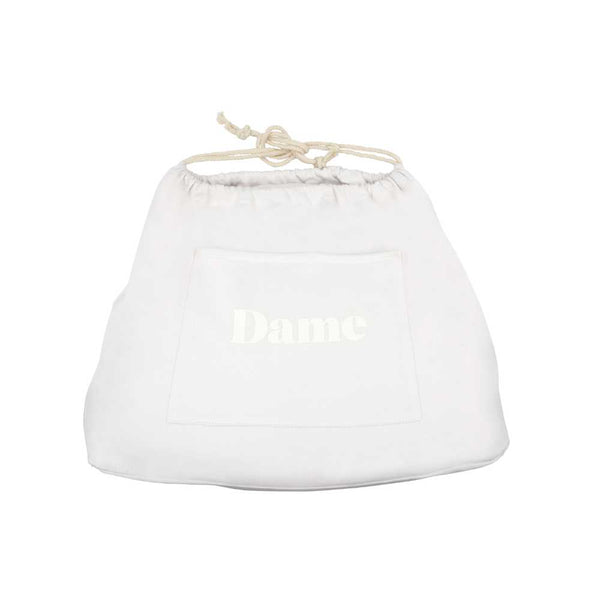 A light-colored drawstring bag featuring a front pocket and adorned with the "Dame" brand elegantly printed on it, designed for durability and convenience. This simple design makes it ideal for storing essentials like your Dame Pillo - Sex Pillow Wedge made from medical-grade silicone.