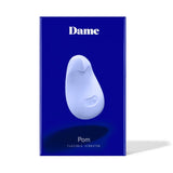 The dark blue box of the Dame Pom - External Flexible Vibrator, made from medical-grade silicone, is displayed elegantly against a white background. A sleek white image of the product is featured in the center with 