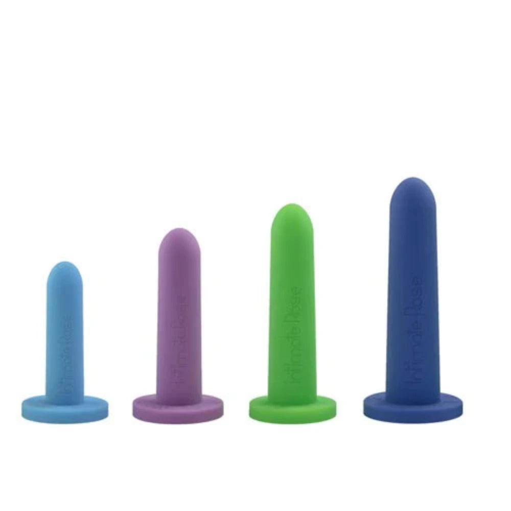 The Intimate Rose Silicone Vaginal Dilators - Medium Set by Intimate Rose consists of four cylindrical objects in varying sizes, each featuring a flat base and made from silicone for gradual progression. They are arranged from smallest to largest in colors light blue, purple, green, and dark blue.